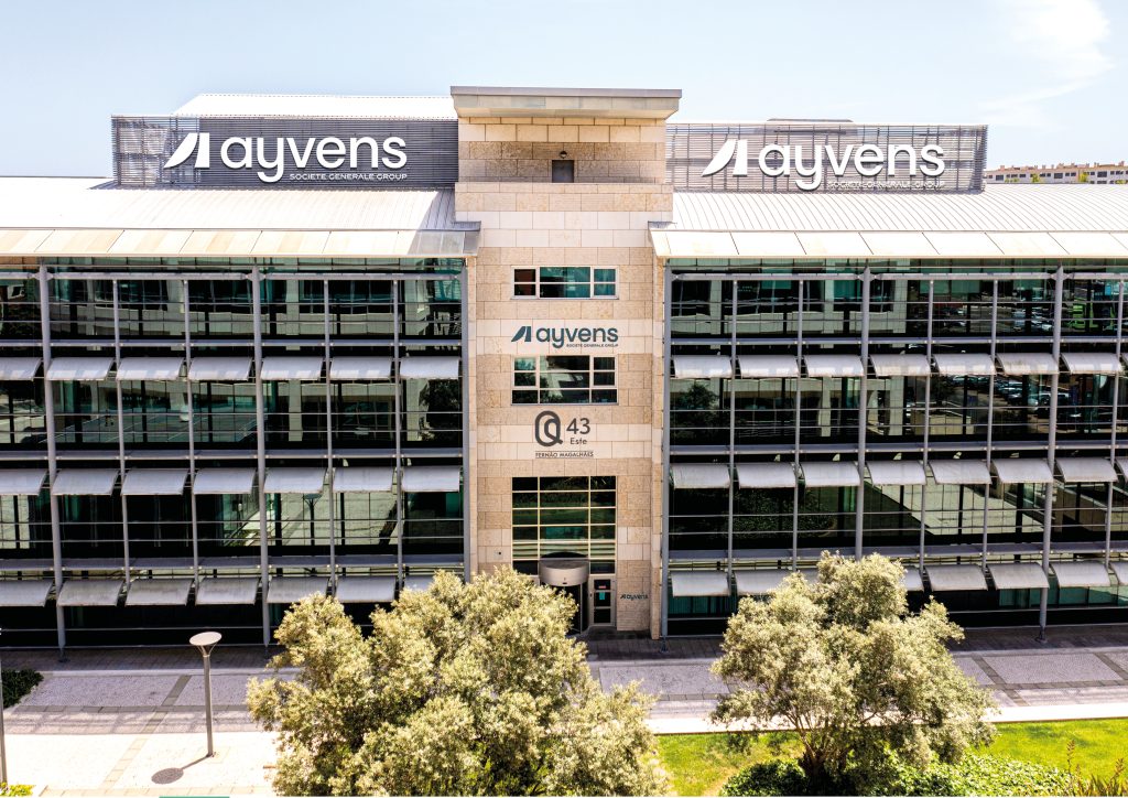 Fotomontagem apresentando o conceito de Aplicação na fachada do logótipo no projeto Ayvens, localizado em Oeiras, Portugal.