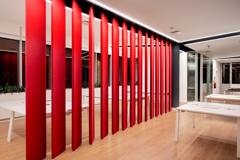 Fotografia apresentando o conceito de divisória em painéis acústicos rotativos no projeto Sede Banco Primus, localizado em Oeiras, Portugal.