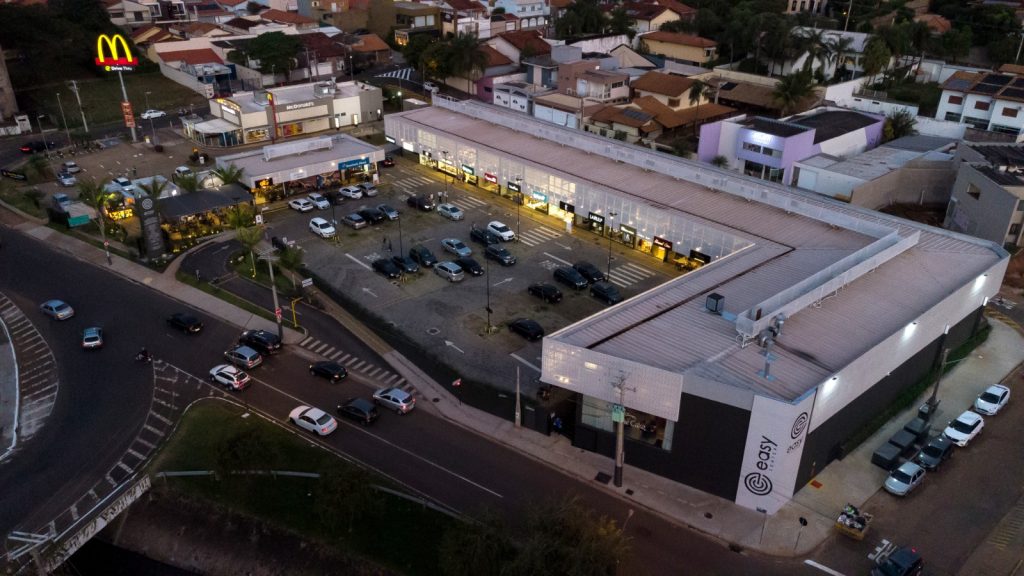 Fotografia apresentando o conceito de Vista aérea da envolvente urbana e implantação no projeto Franca Strip Mall, localizado em São Paulo, Brasil.