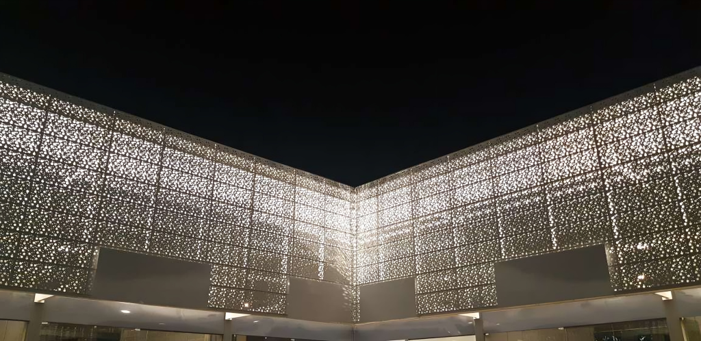 Fotografia apresentando o conceito de Detalhe da fachada e iluminação, vista de noite no projeto Franca Strip Mall, localizado em São Paulo, Brasil.