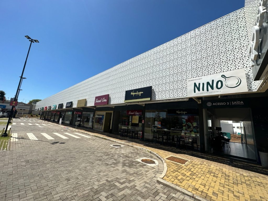 Fotografia apresentando o conceito de Vista exterior da frente de lojas no projeto Franca Strip Mall, localizado em São Paulo, Brasil.