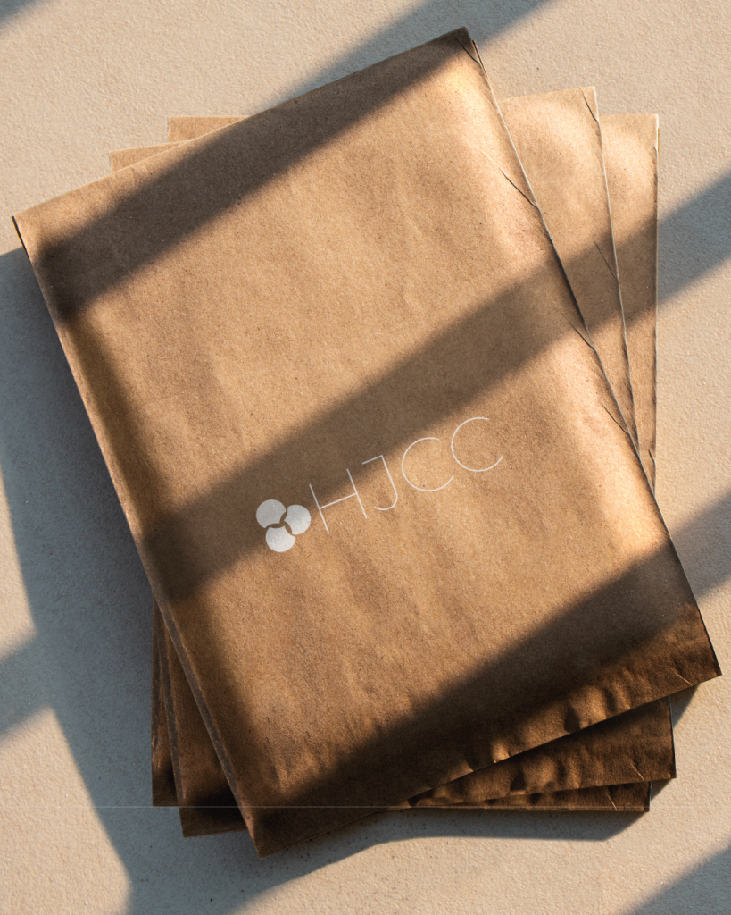 Fotomontagem apresentando a Aplicação em envelopes no projeto Logótipo HJCC, localizado em Lisboa, Portugal.