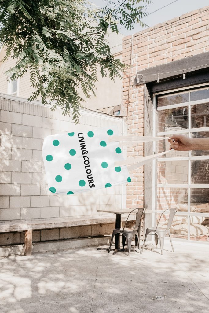 Fotomontagem apresentando a Aplicação em bolsa no projeto Logótipo Living Colours, localizado em Lisboa, Portugal.