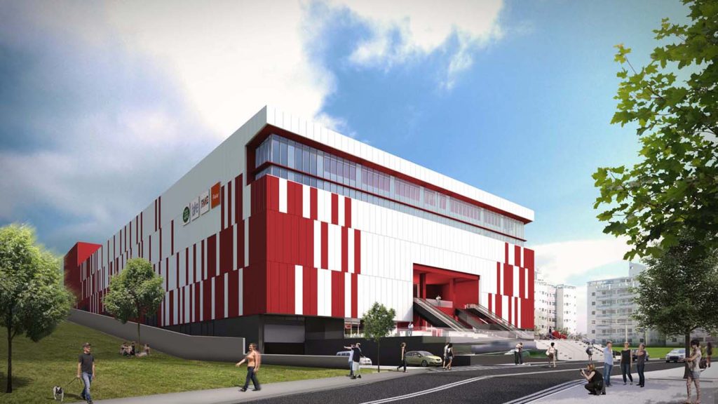 Vista externa do projeto Praça Americana Shopping Center, com escadas rolantes de acesso e fachada com ritmo de painéis de cor vermelho e branco..