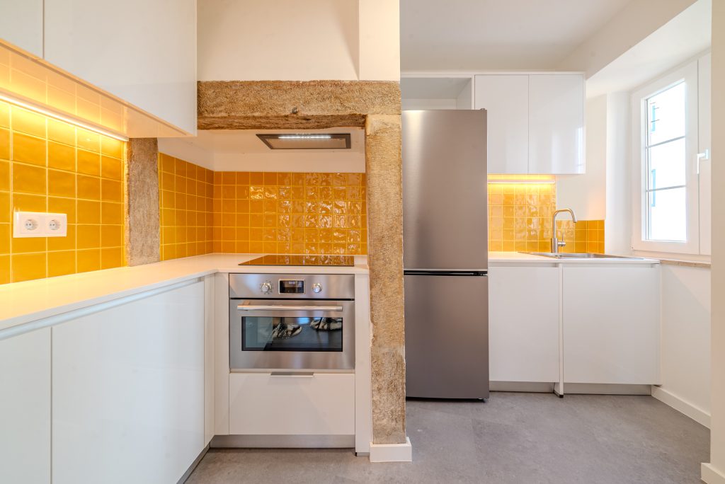Fotografia apresentando a Cozinha e chaminé antiga preservada no projeto Rua das Praças, localizado em Lisboa, Portugal.